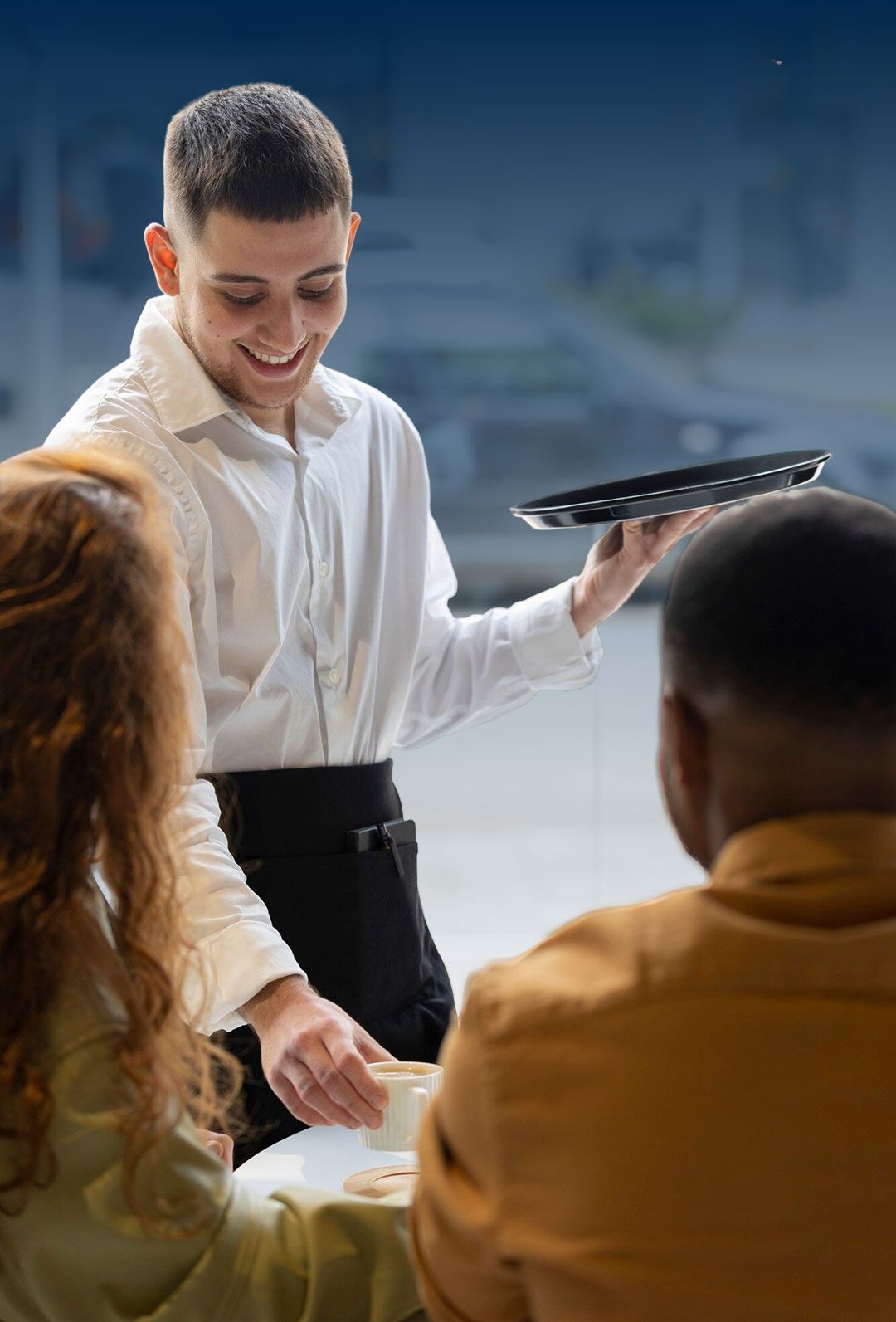 
Restaurant employee serving food to smiling customers