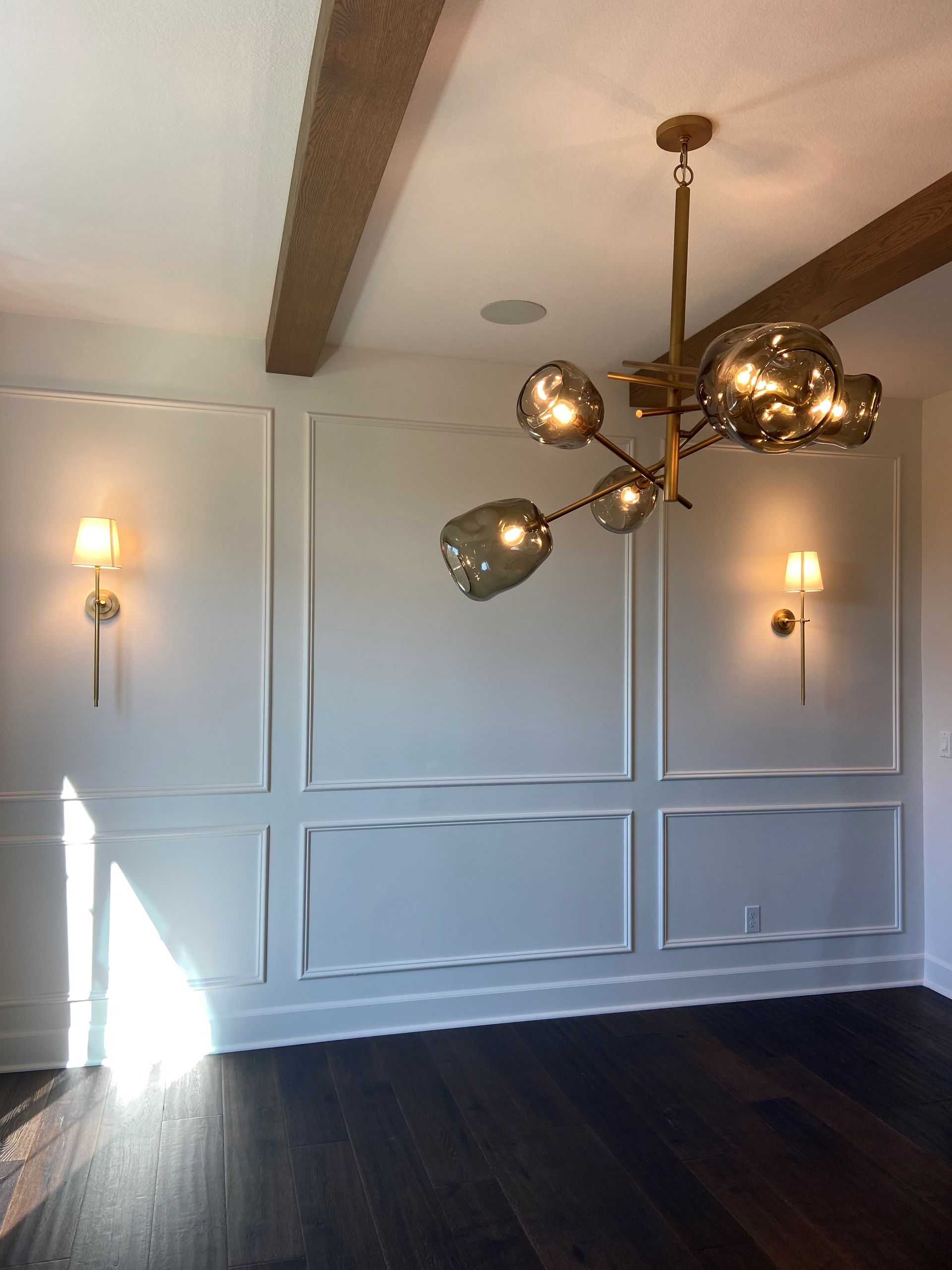 An empty room with a chandelier hanging from the ceiling