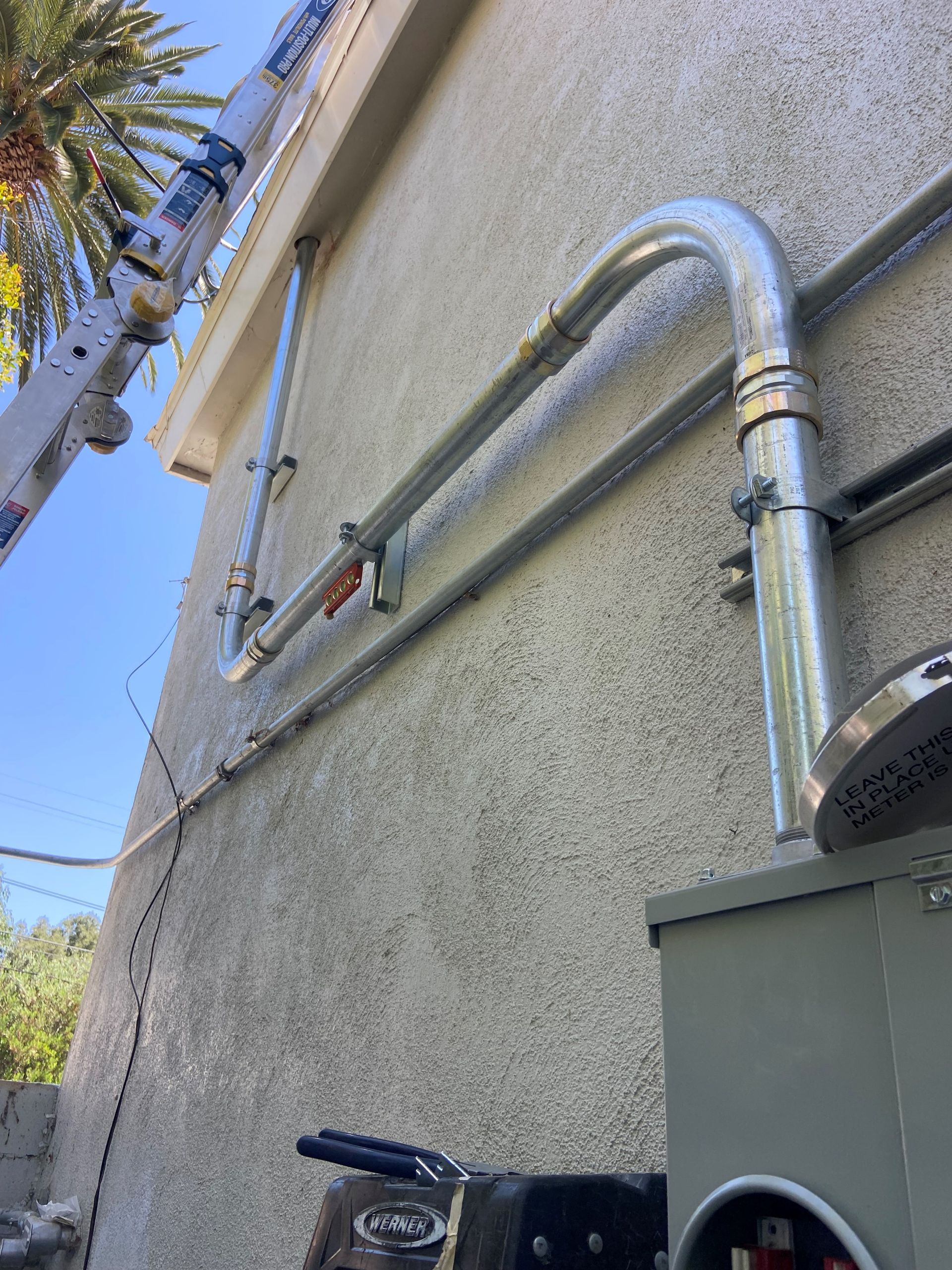 A metal pipe is attached to the side of a building.