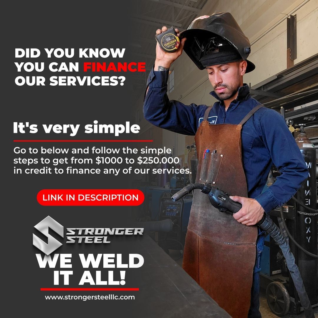 A man wearing a welding helmet and apron is holding a welding machine.