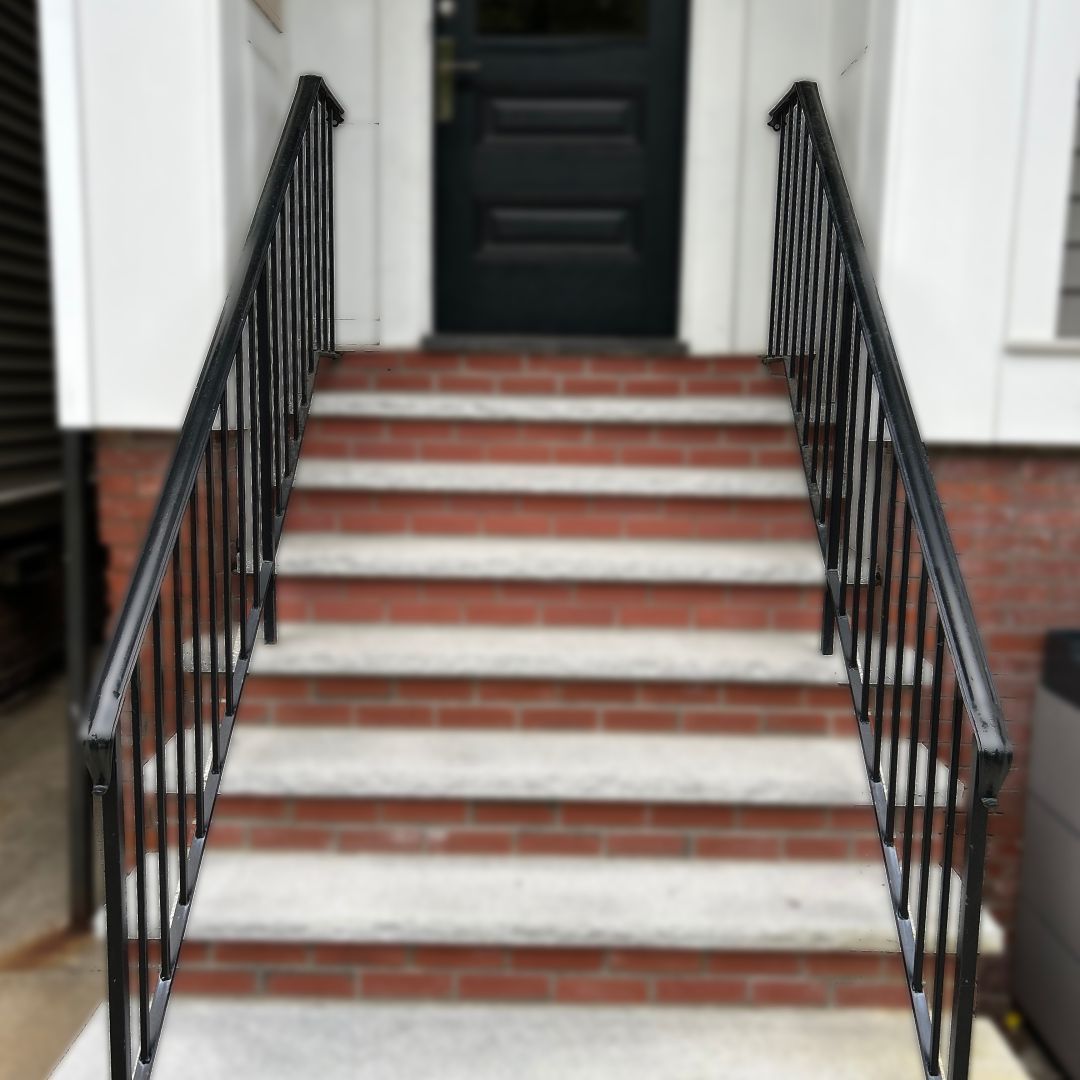 A set of stairs leading up to a black door