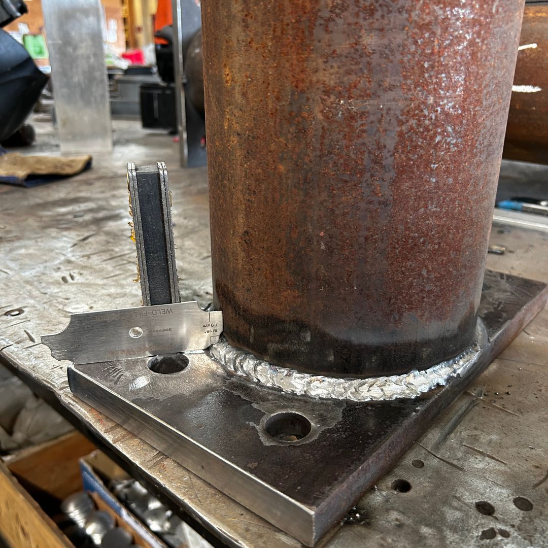 A piece of rusty metal is sitting on top of a metal plate on a table.
