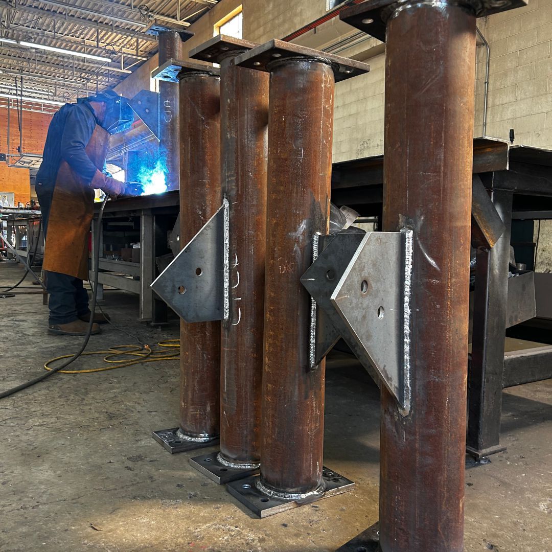 A man is welding a piece of metal in a factory