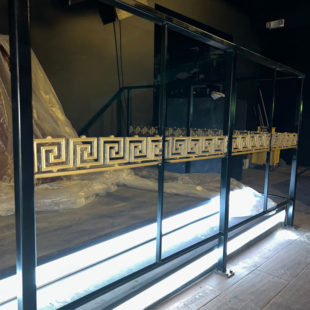 A metal railing with a greek key design on it