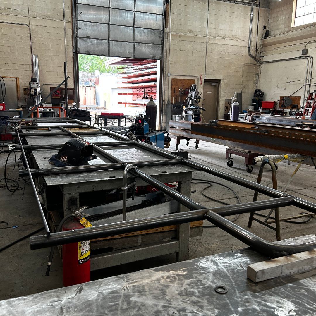A large metal structure is being built in a factory.