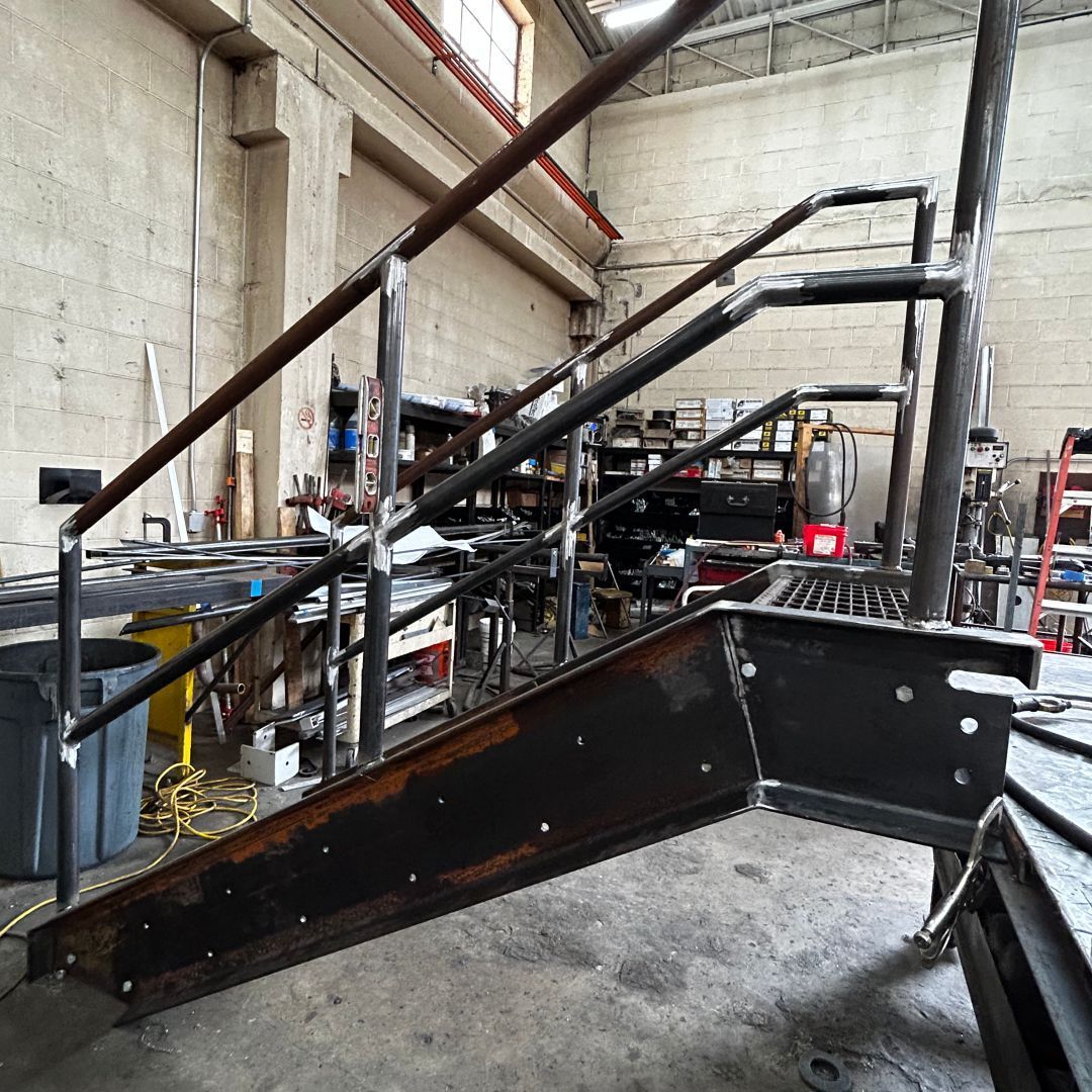 A metal staircase is being built in a factory.