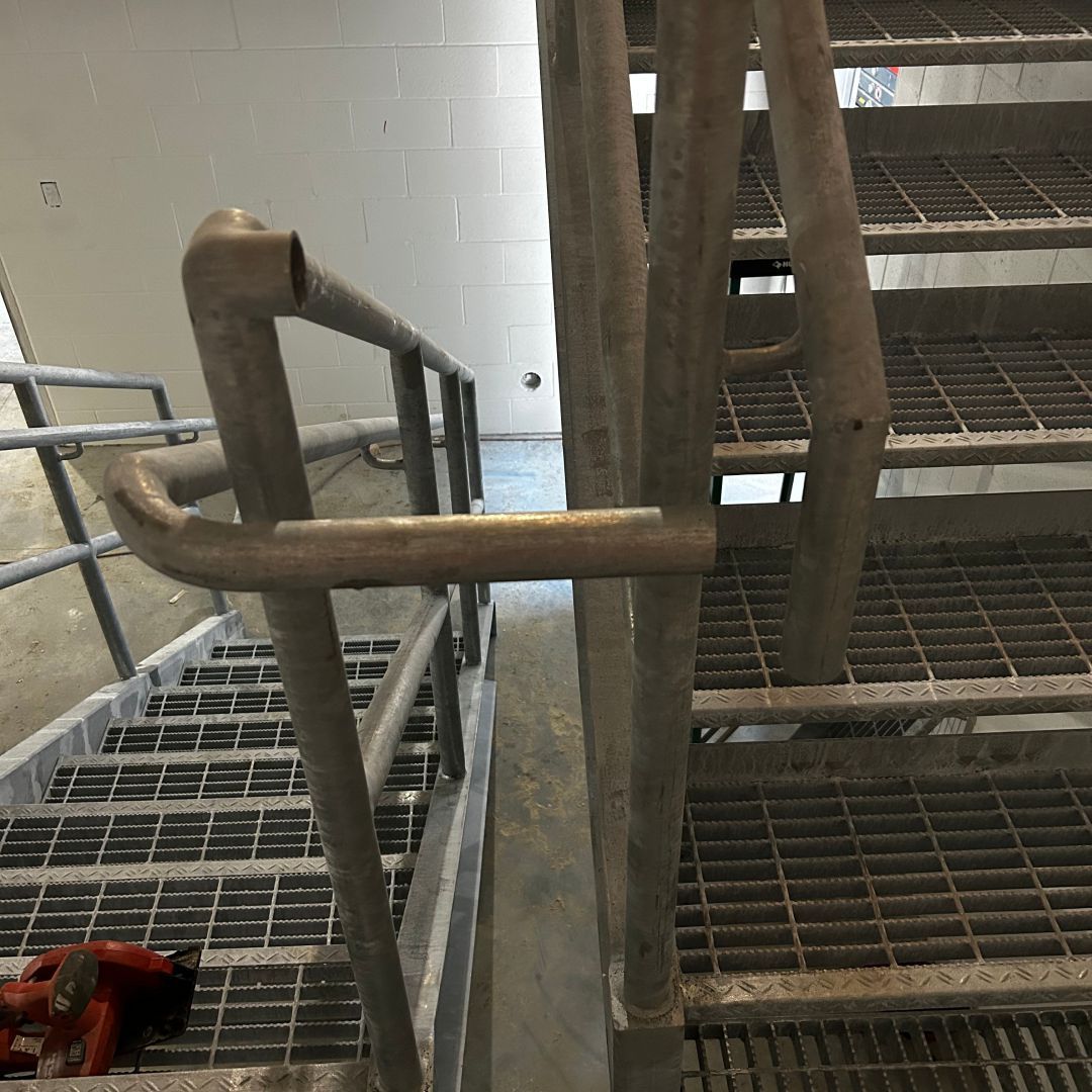 A close up of a metal staircase with a metal railing.