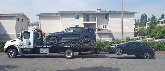 Roadside Assistance — Two Black Cars on Tow Truck in Seattle, WA