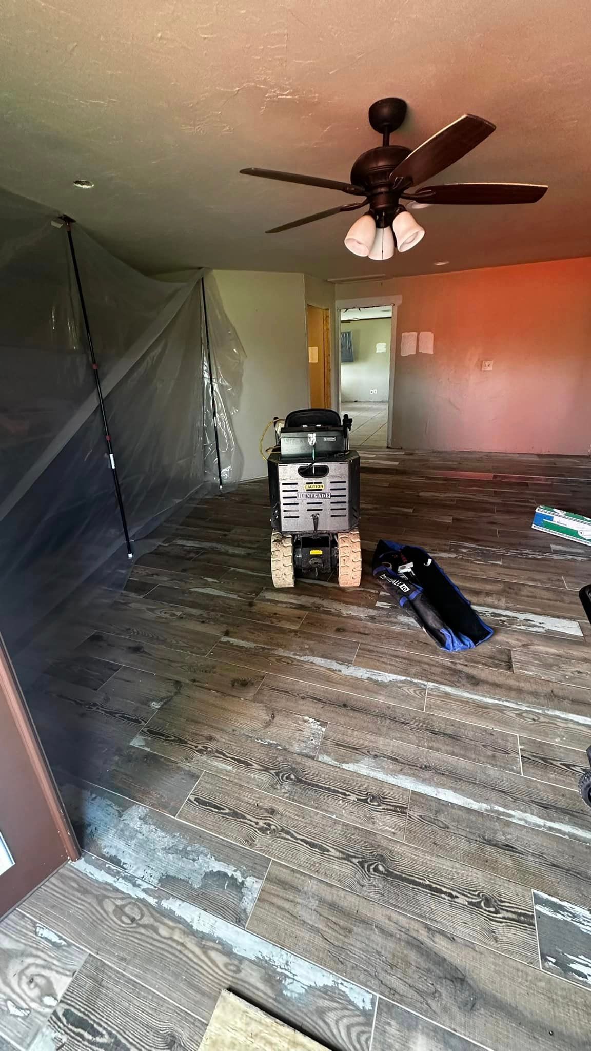 A living room with a ceiling fan and a snow blower.