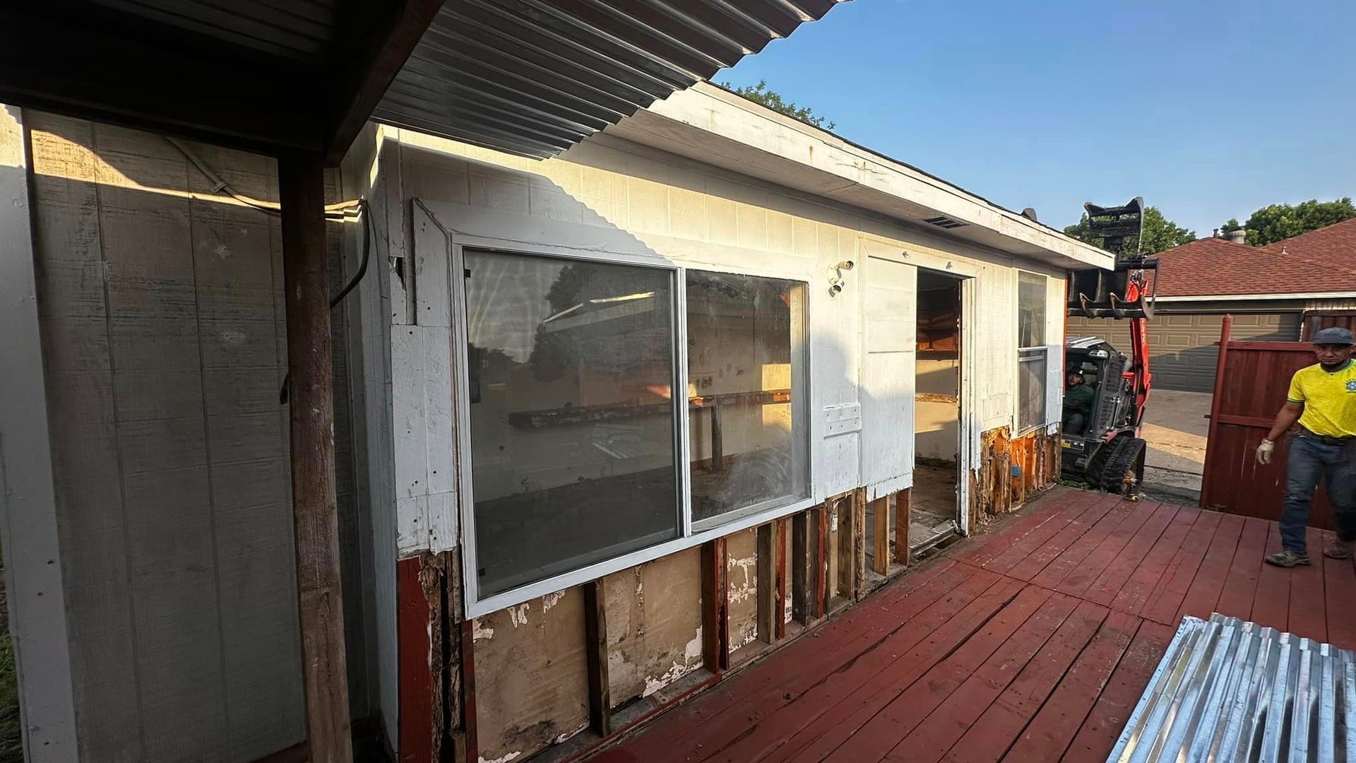 A man is standing in front of a house that is being demolished.