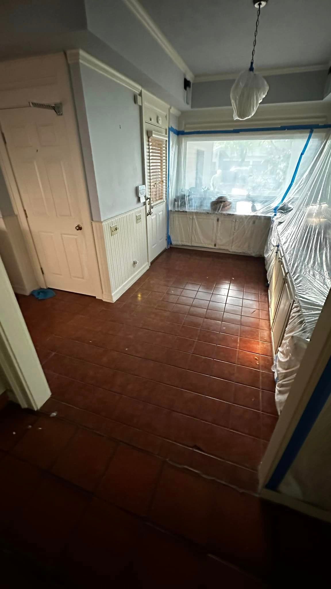 A room with a red tile floor and a window.