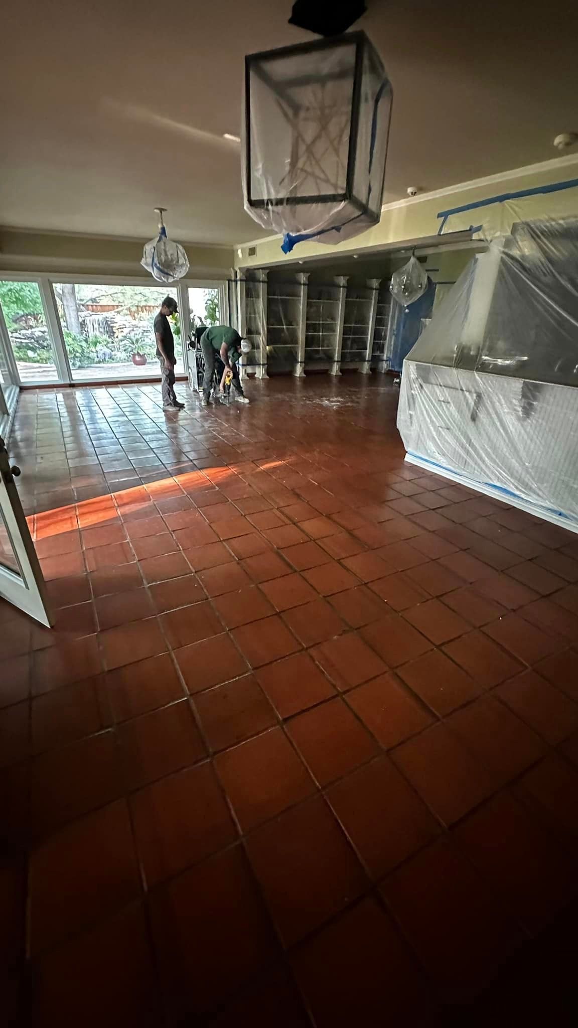 A large room with a tiled floor and a lantern hanging from the ceiling.