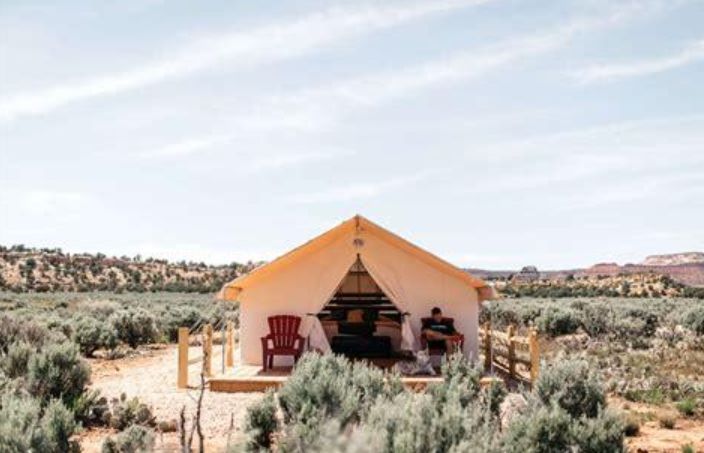 A tent is sitting in the middle of a desert.