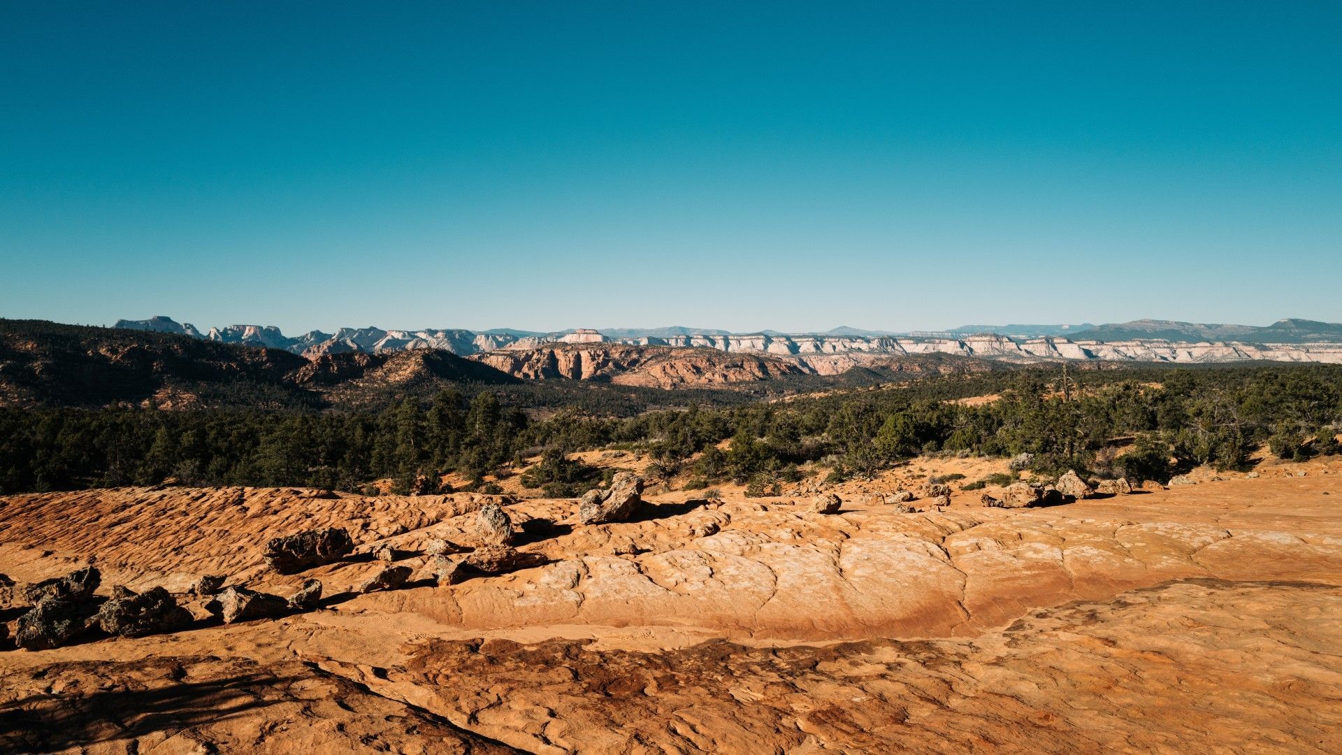 A desert landscape with mountains in the background and a blue sky