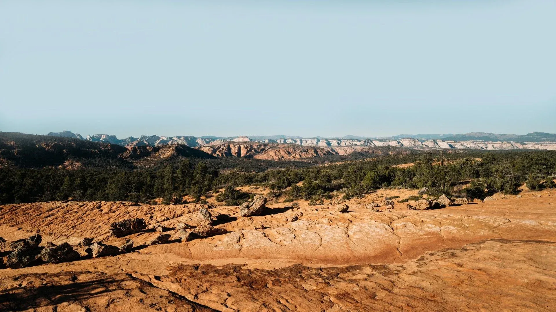 A desert landscape with mountains in the background and a blue sky