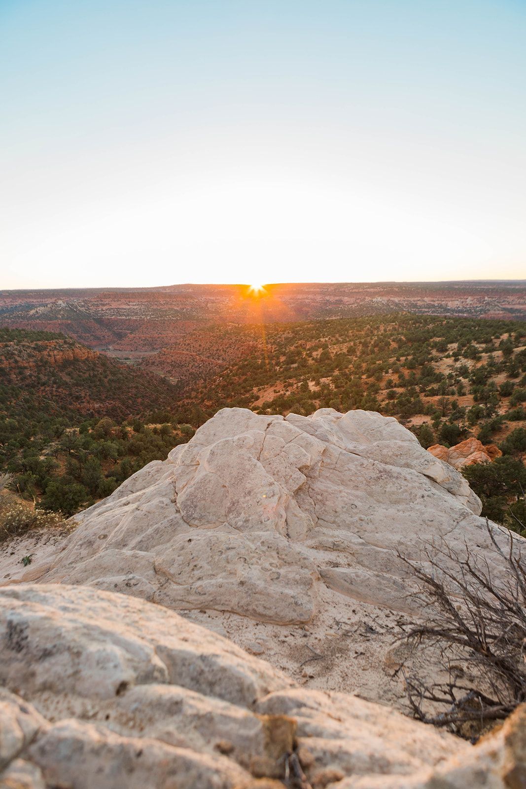The sun is setting over a mountain in the desert.