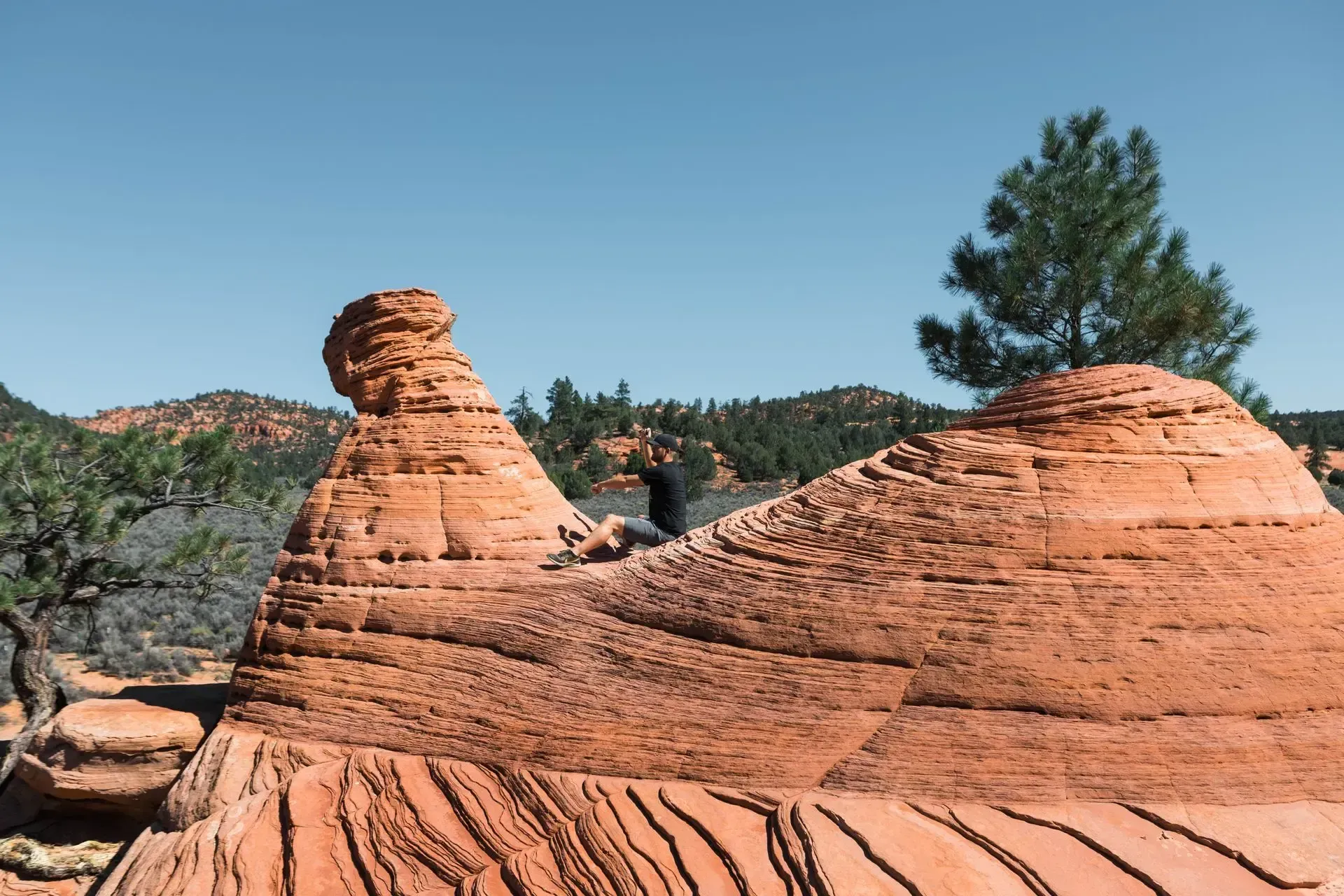 Red sandstone rock formations under a clear blue sky in a desert landscape