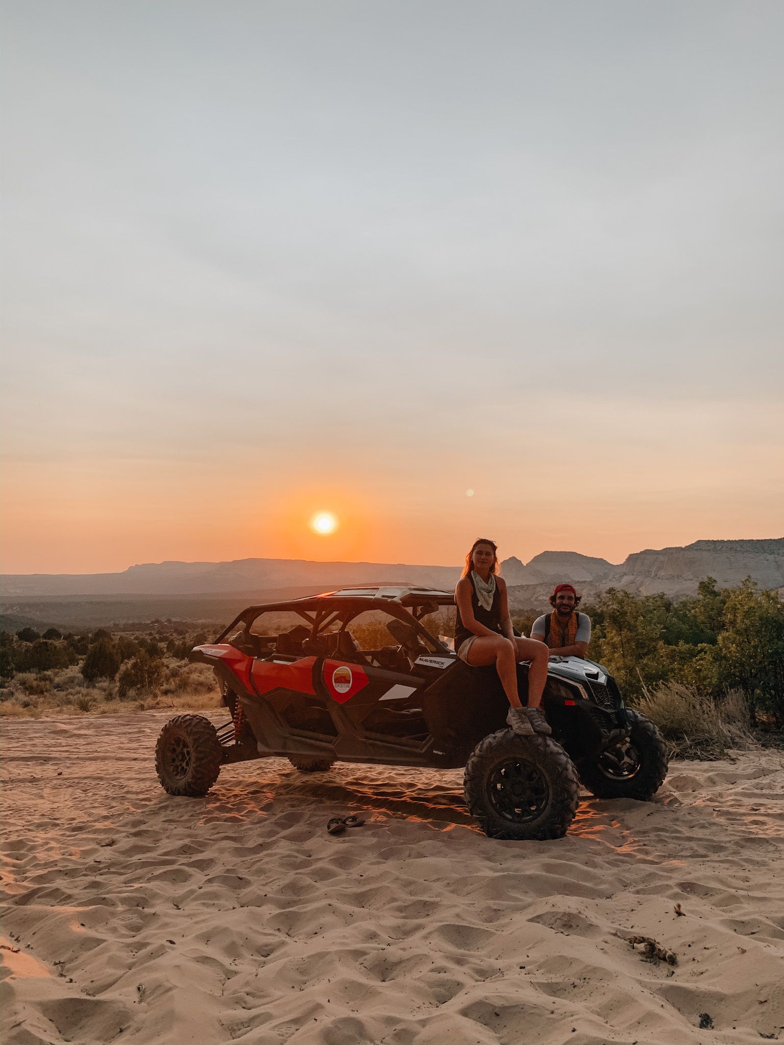A green atv is parked in the sand in the desert.