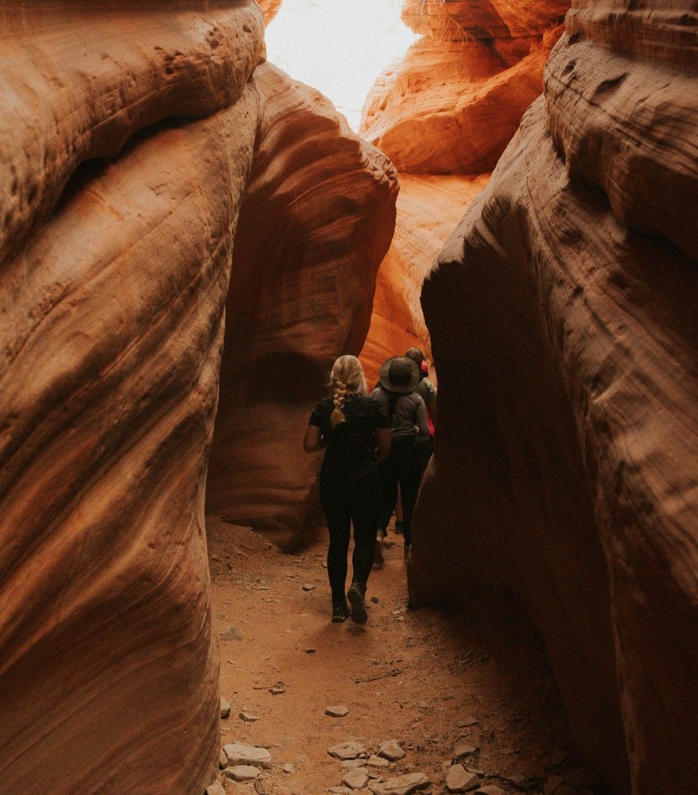 Two women are sitting on a red atv in the sand at sunset