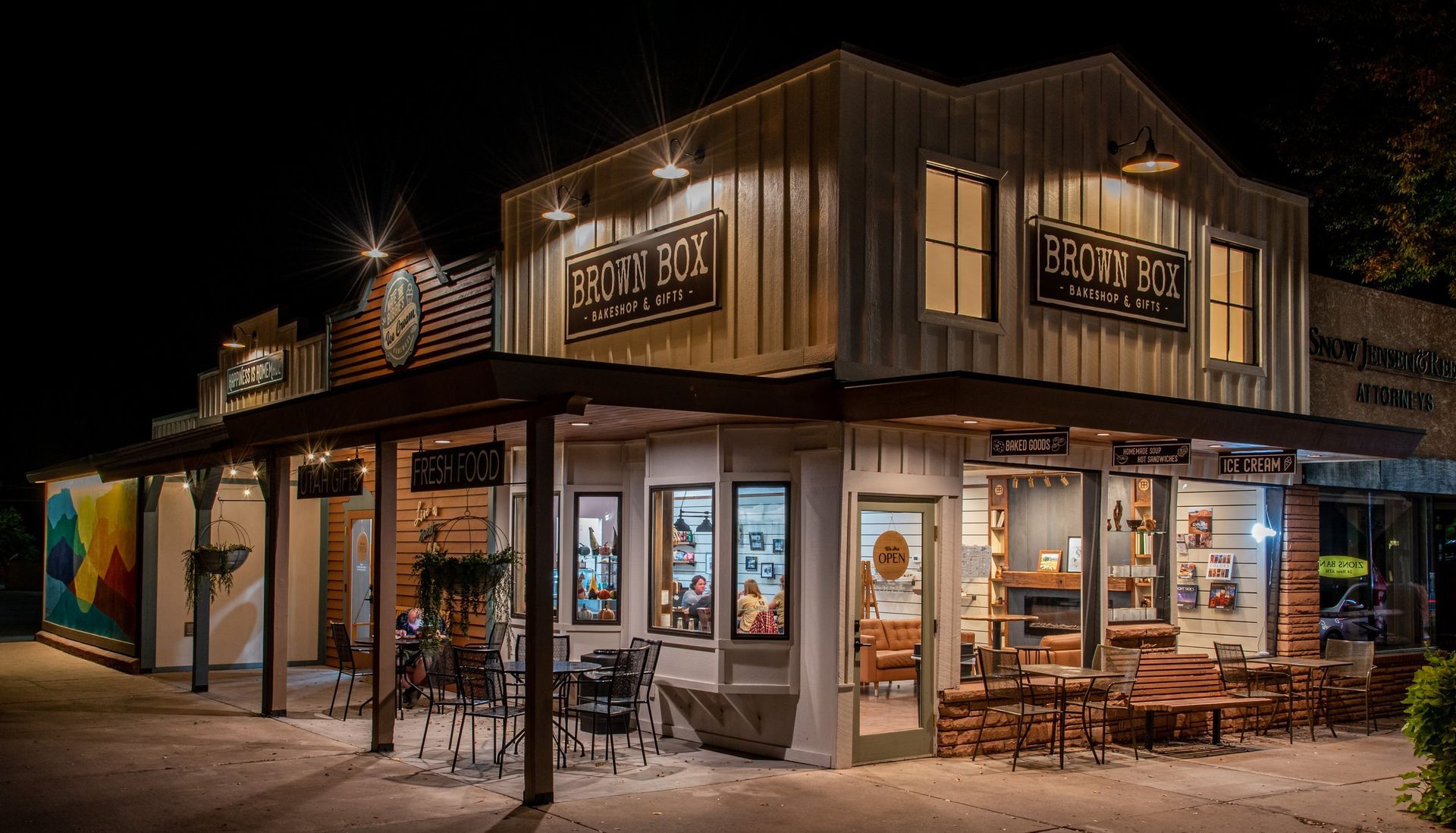 A large white building with a lot of windows is lit up at night.