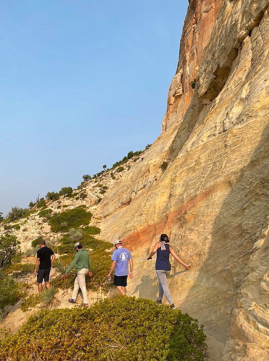 A group of people are walking up a cliff.