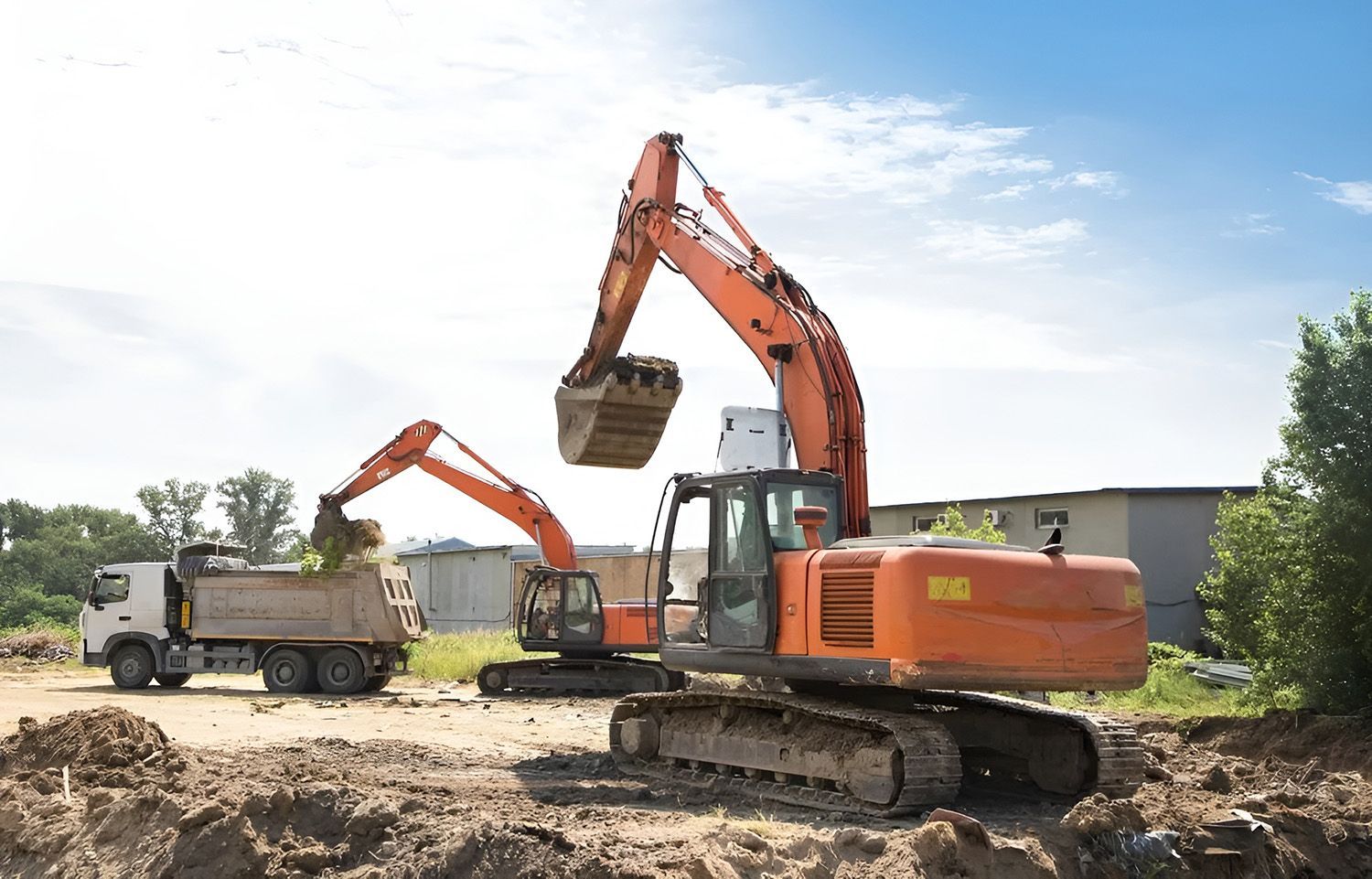 Orange Excavators Loading a Dump Truck at a Construction Site