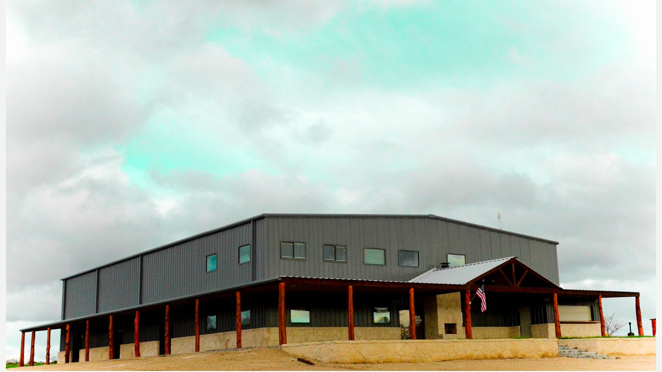 A large office building with a porch and a flag on top of it