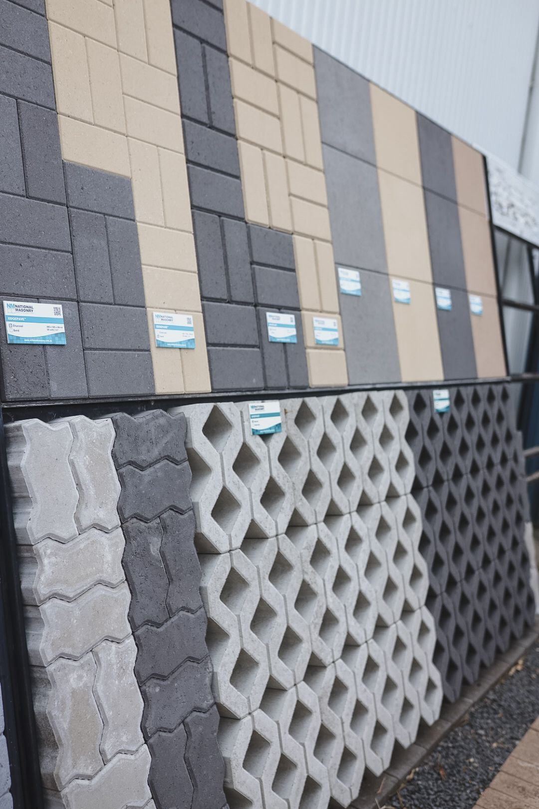 Exterior wall with grey, beige, and patterned concrete panels on a building facade — Hunter Valley Bricks & Pavers in Scone, NSW