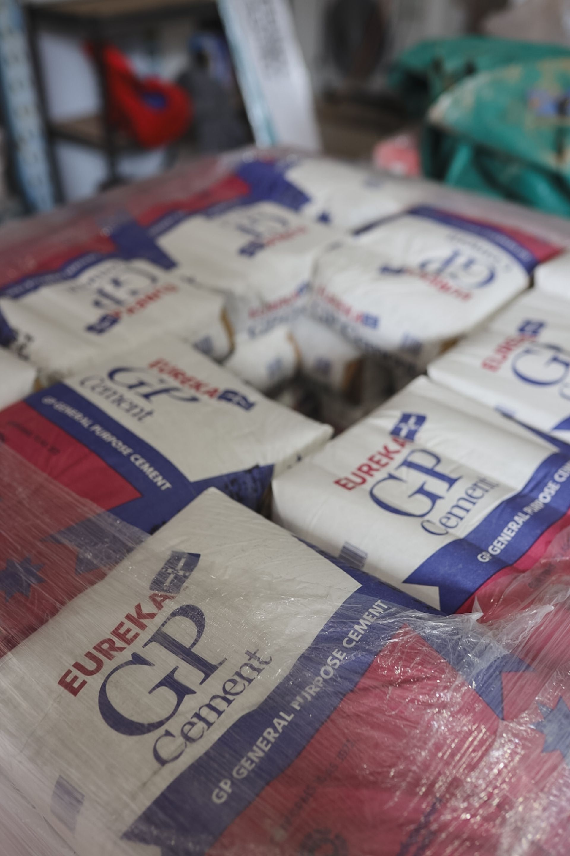 Stacked bags of white cement on a red pallet, wrapped in plastic. — Hunter Valley Bricks & Pavers in Scone, NSW
