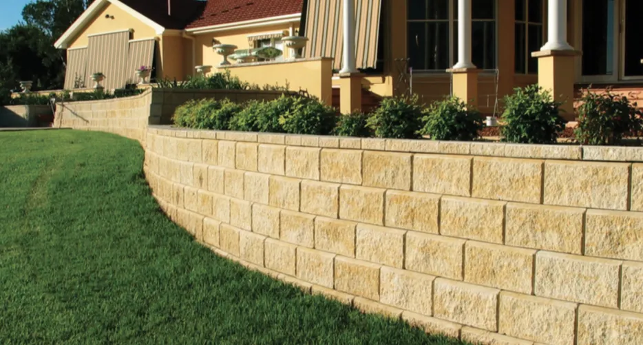 Curved Tan Retaining Wall With Green Grass Lawn — Hunter Valley Bricks & Pavers in Scone, NSW