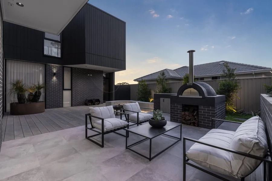 Outdoor Patio With Black Brick Pizza Oven, Modern Furniture — Hunter Valley Bricks & Pavers in Scone, NSW