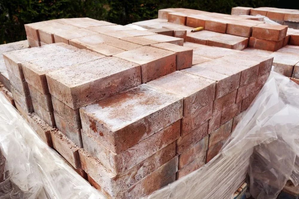 Stacks of Red Bricks on a Pallet, Covered in a White Residue — Hunter Valley Bricks & Pavers in Singleton, NSW
