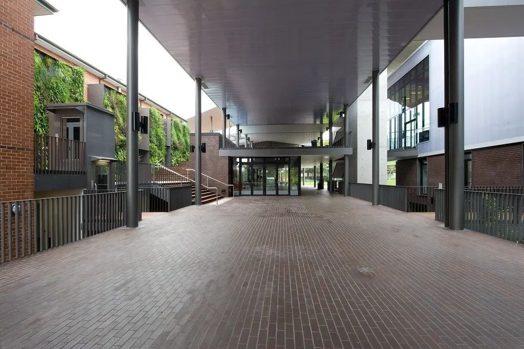 Covered Walkway With Brick Pavers Leading to a Building Entrance — Hunter Valley Bricks & Pavers in Scone, NSW