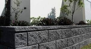 Retaining Wall Made of Dark Grey Blocks With Plants on Top — Hunter Valley Bricks & Pavers in Scone, NSW