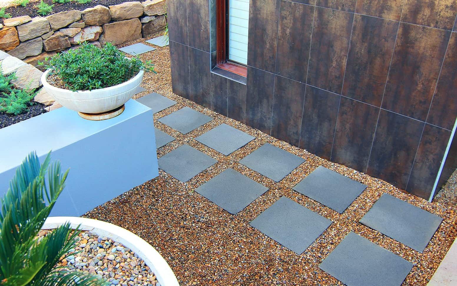 Stepping Stones on Gravel Path Leading to a Building With Dark Tiled Exterior — Hunter Valley Bricks & Pavers in Scone, NSW