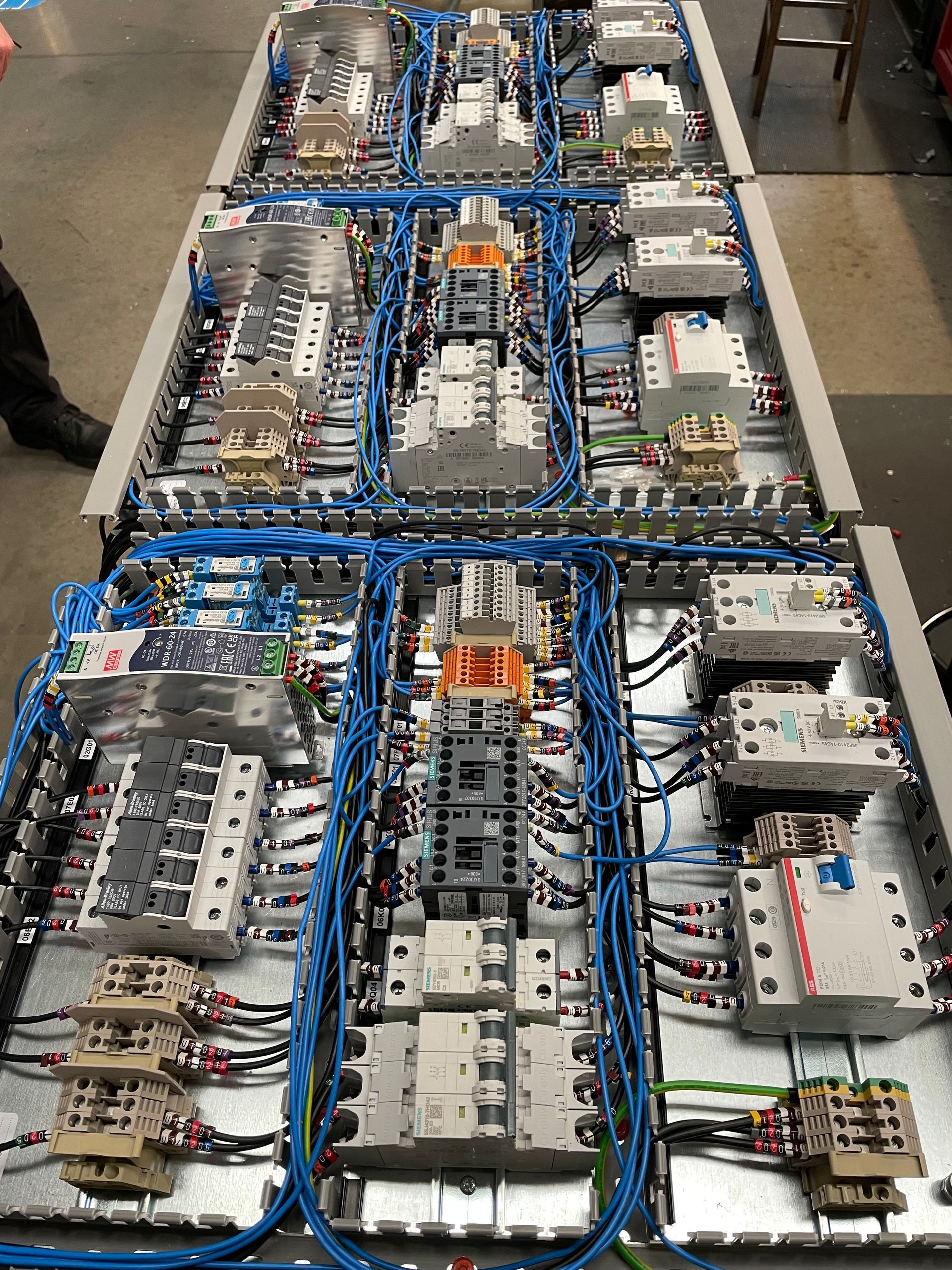 Top view of three small control panel backplates uncovered, showing the internal wiring, switches and relays prior final assembly and test