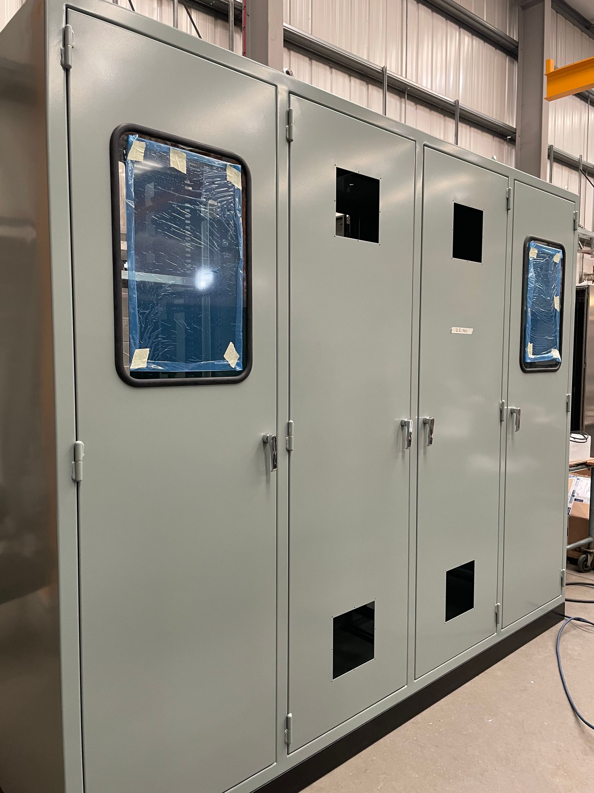 External view of a grey control panel system with HMI panels at either end in the middle of the door panels