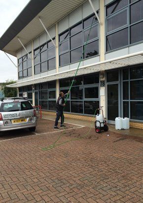Staff cleaning office building window