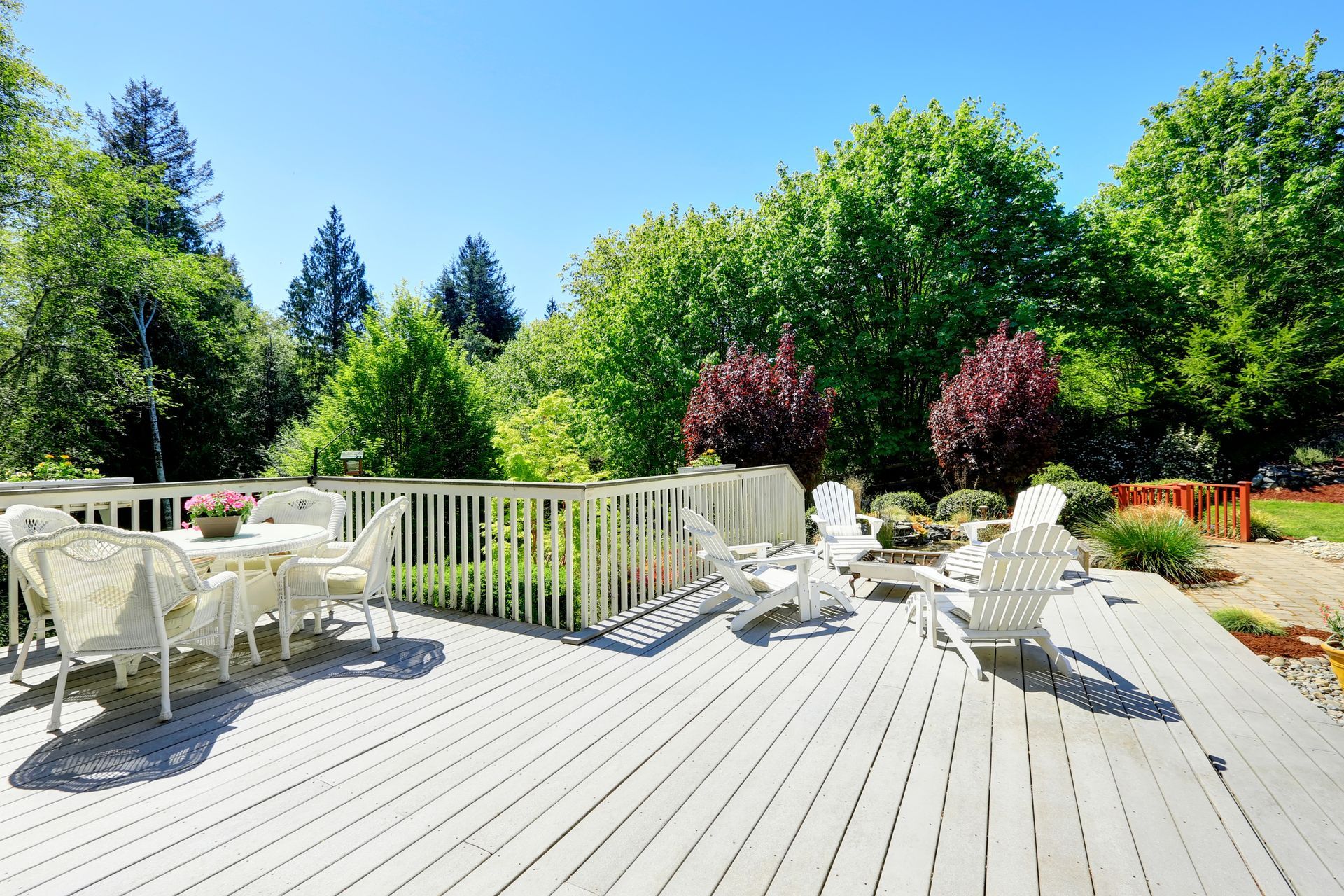 A large deck with a table and chairs on it surrounded by trees - Smyrna, TN - Ryan Home Improvements