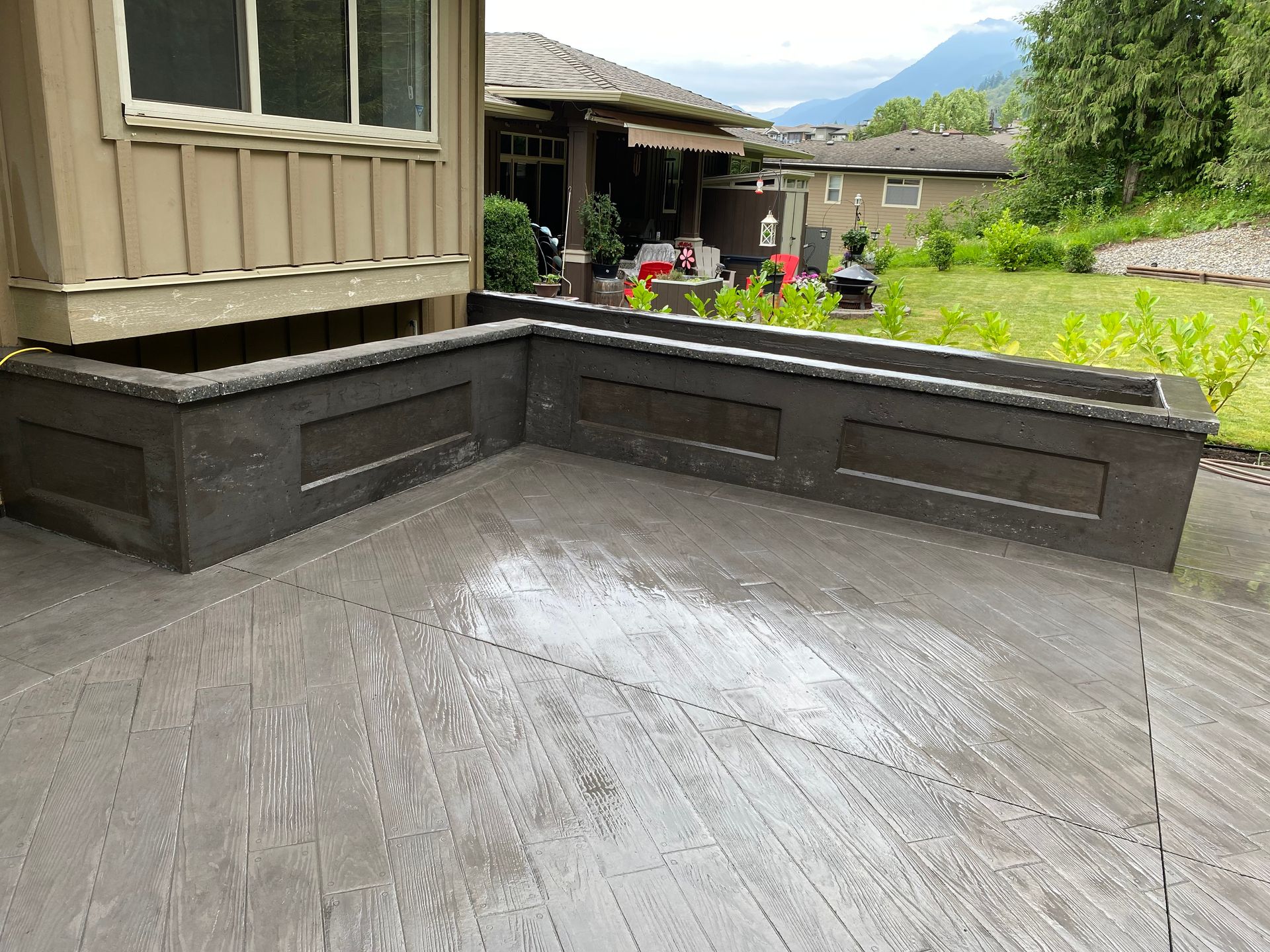 A wooden deck with a house in the background