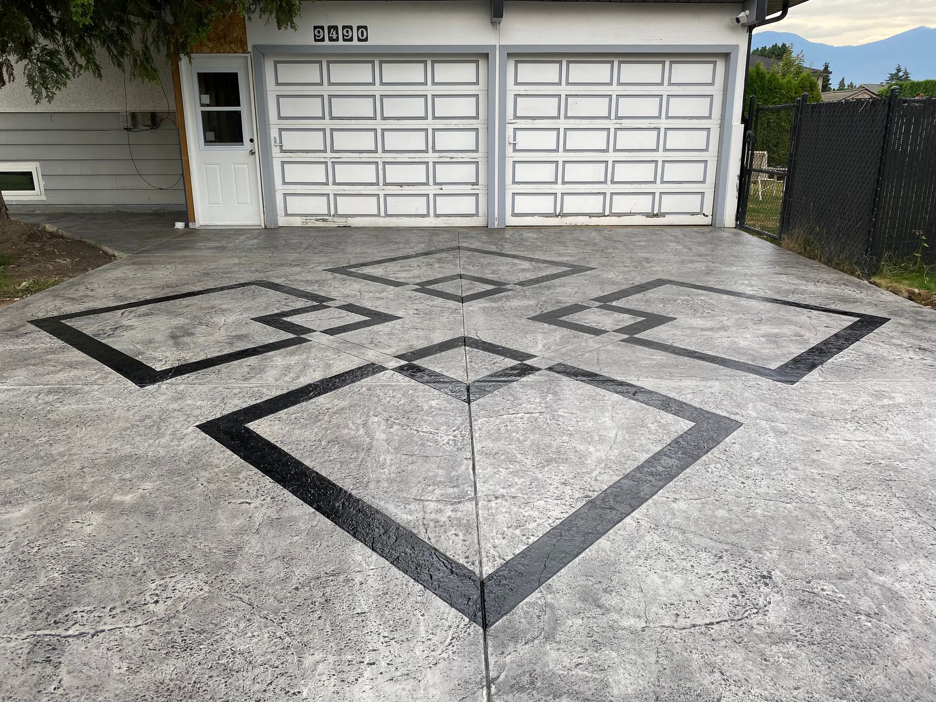 A concrete driveway with a diamond pattern painted on it