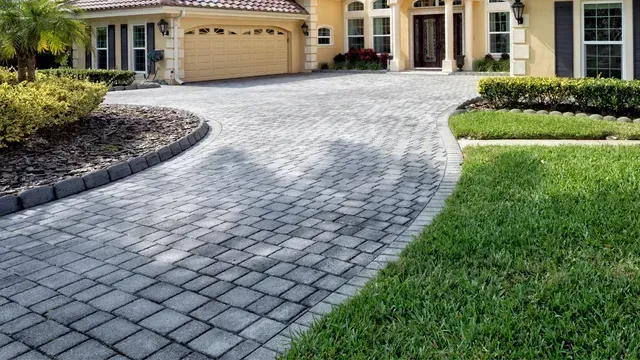 A large house with a brick driveway leading to it.