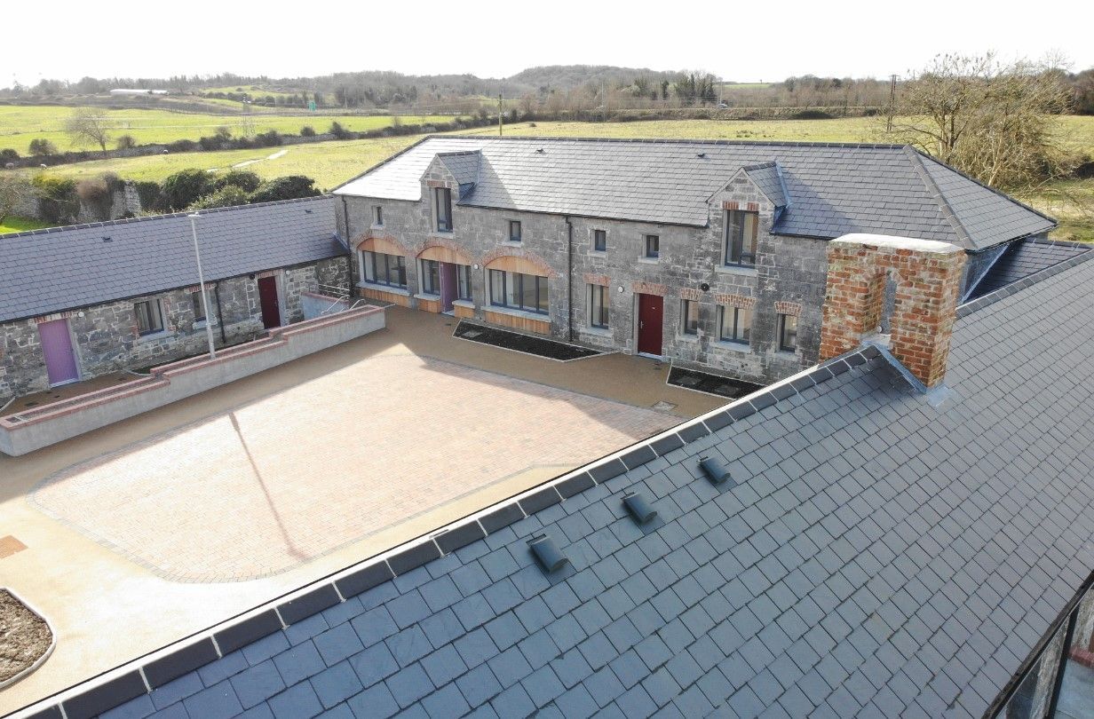 An aerial view of a large house with a slate roof.