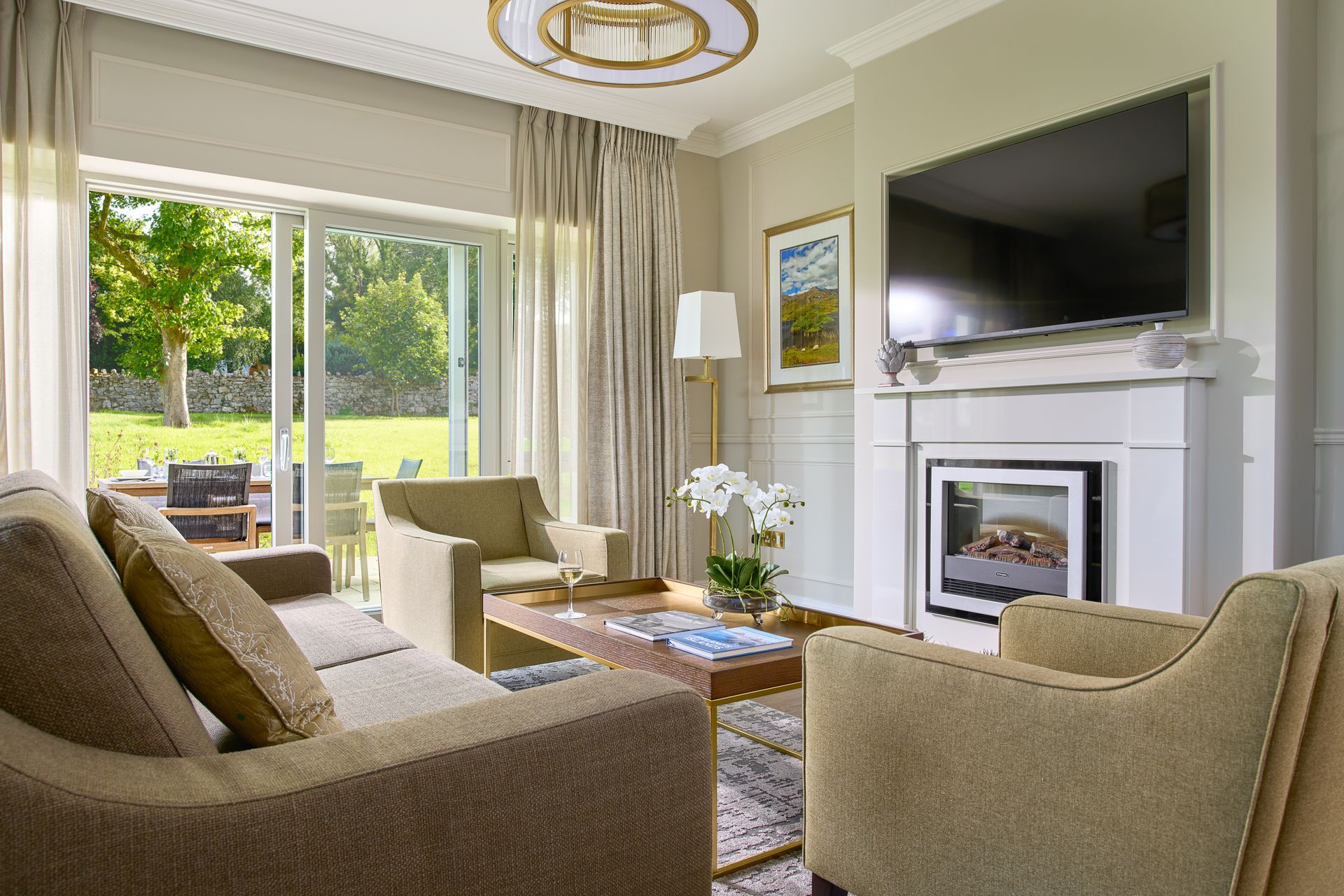 A living room with a couch , chairs , coffee table and television.