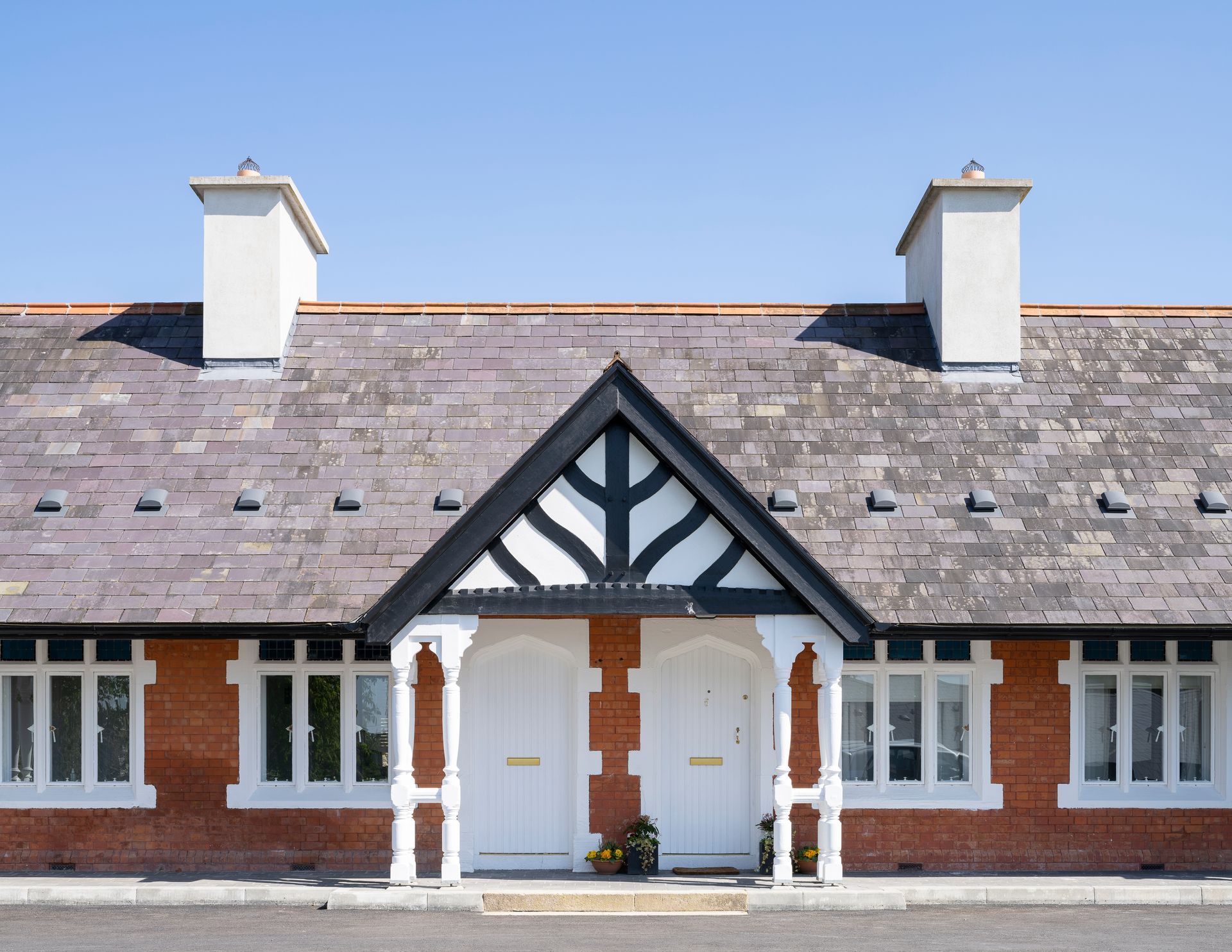 A brick house with a slate roof and chimneys