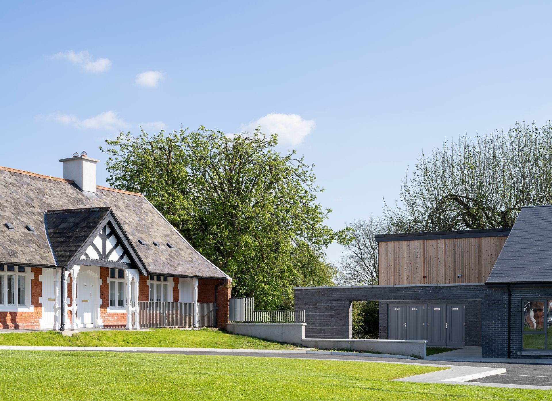 Two houses are sitting next to each other on a lush green hillside.