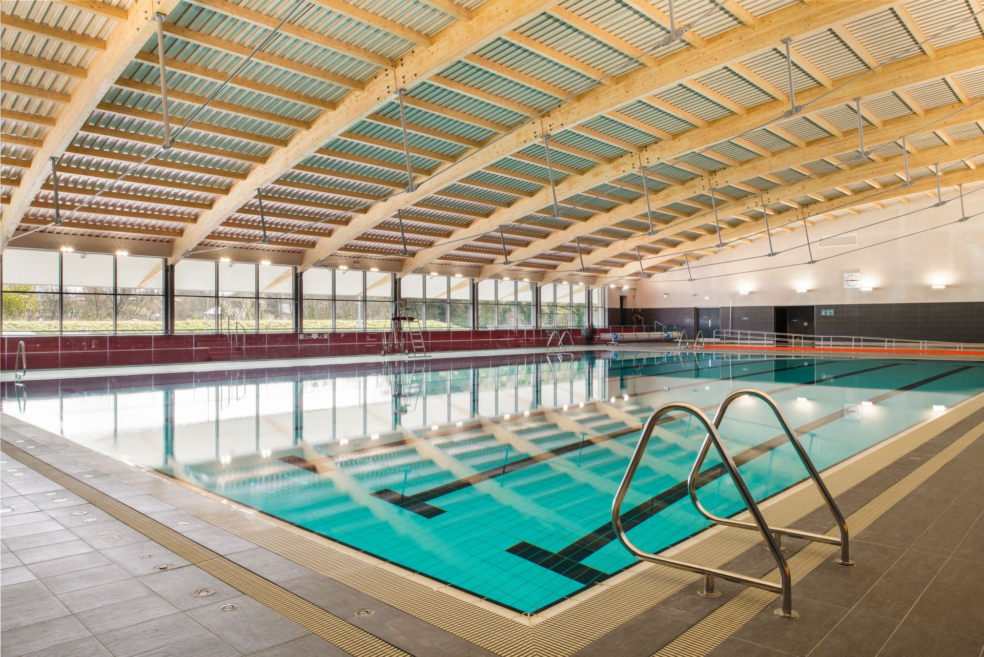 A large indoor swimming pool with a wooden roof