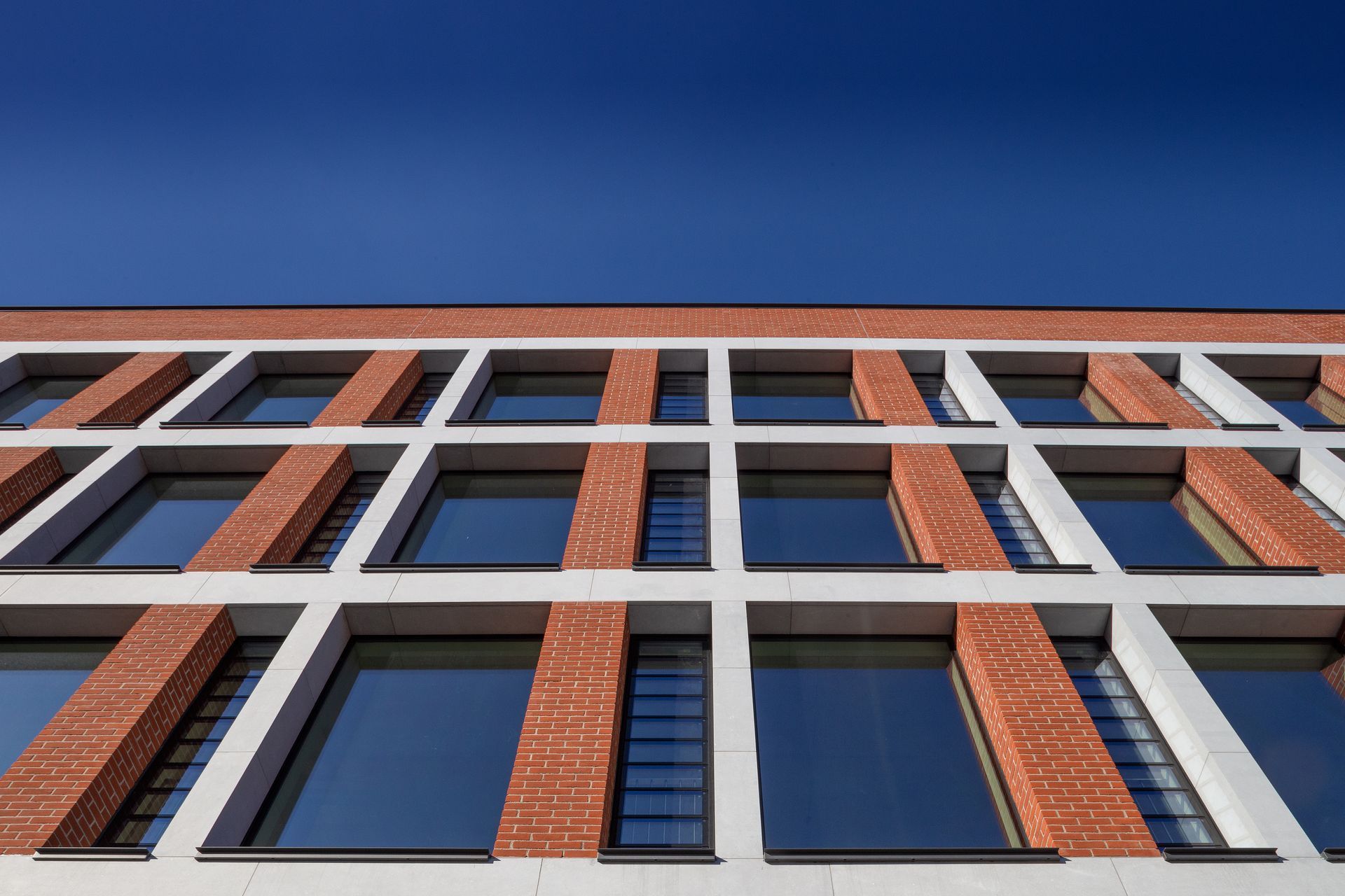 Looking up at a brick building with a blue sky in the background.