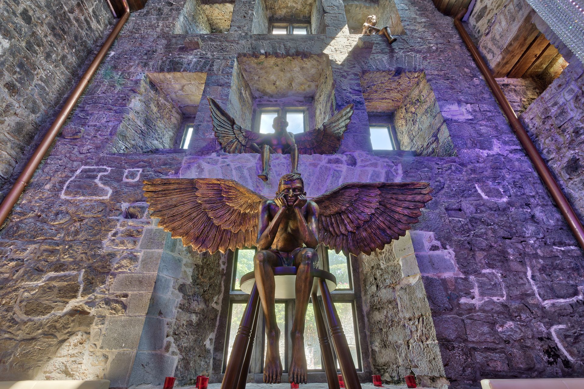 A statue of an angel is sitting in front of a brick building.