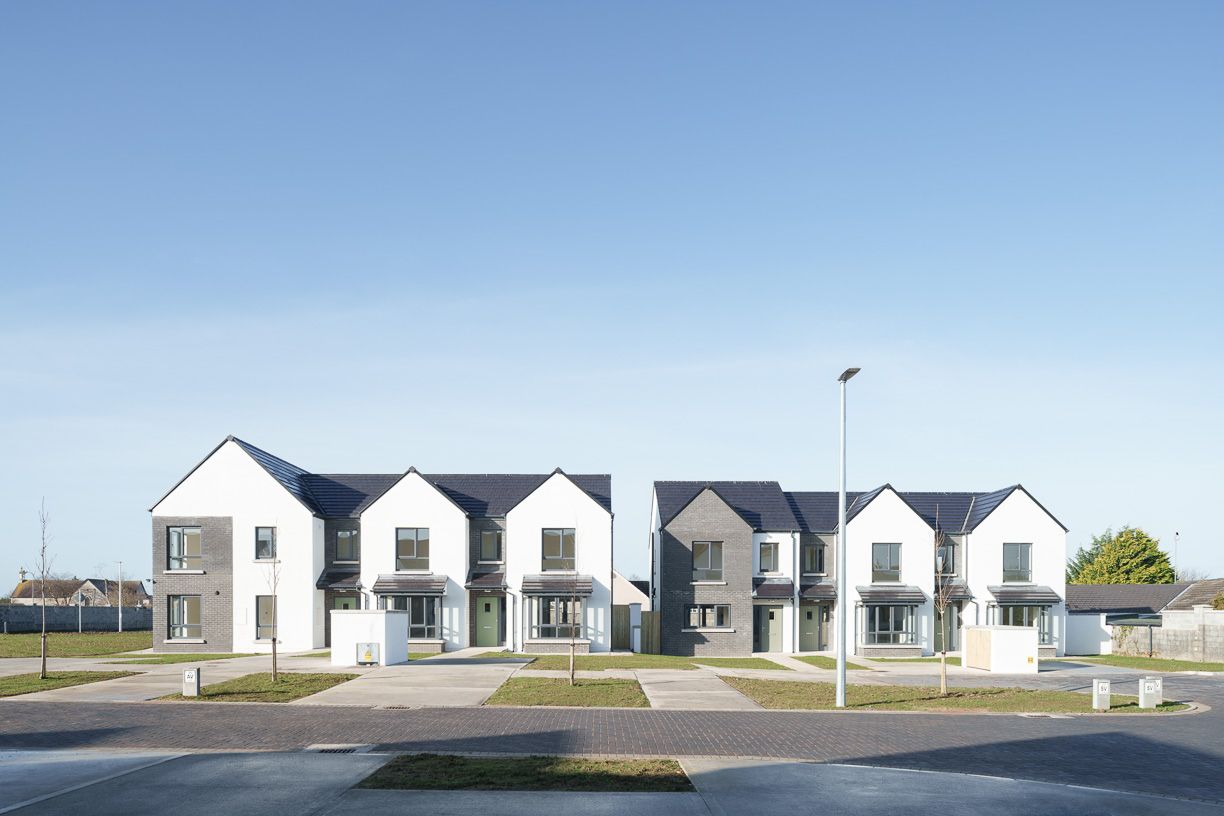 A row of houses in a residential area with a blue sky in the background.